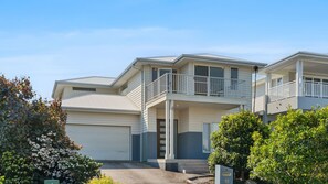 A two-story residential building with a balcony, a garage, and a well-maintained garden. - Catherine Hill Bay - Ocean Views & Coastal Living (Catherine Hill Bay)