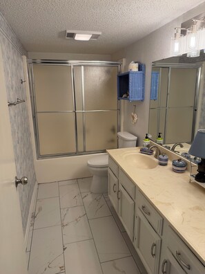 Ein Badezimmer mit Toilette, Waschbecken und Dusche.