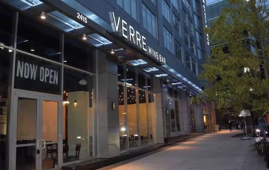 A building with a sign that reads 'VERRE WINE BAR' and 'NOW OPEN'.