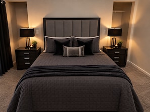 Ein Schlafzimmer mit einem großen Bett, zwei Nachttischen und einer Kopfteil.