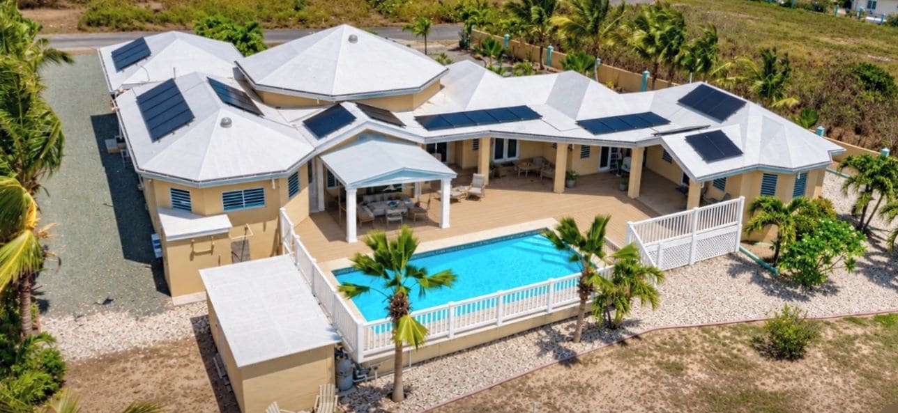 A residential property with multiple houses, a swimming pool, and a covered patio area.