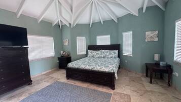 A bedroom with a bed, dresser, and a television.