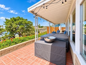 A covered outdoor seating area with a table and chairs, a decorative bowl, and a view of the ocean and trees. -  Views!!! Single level La Jolla, CA. home with panoramic ocean and city views! (San Diego)