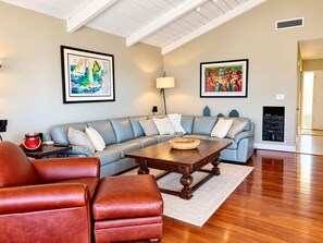 A living room with a sectional sofa, leather armchairs, a wooden coffee table, and artwork on the walls. -  Views!!! Single level La Jolla, CA. home with panoramic ocean and city views! (San Diego)