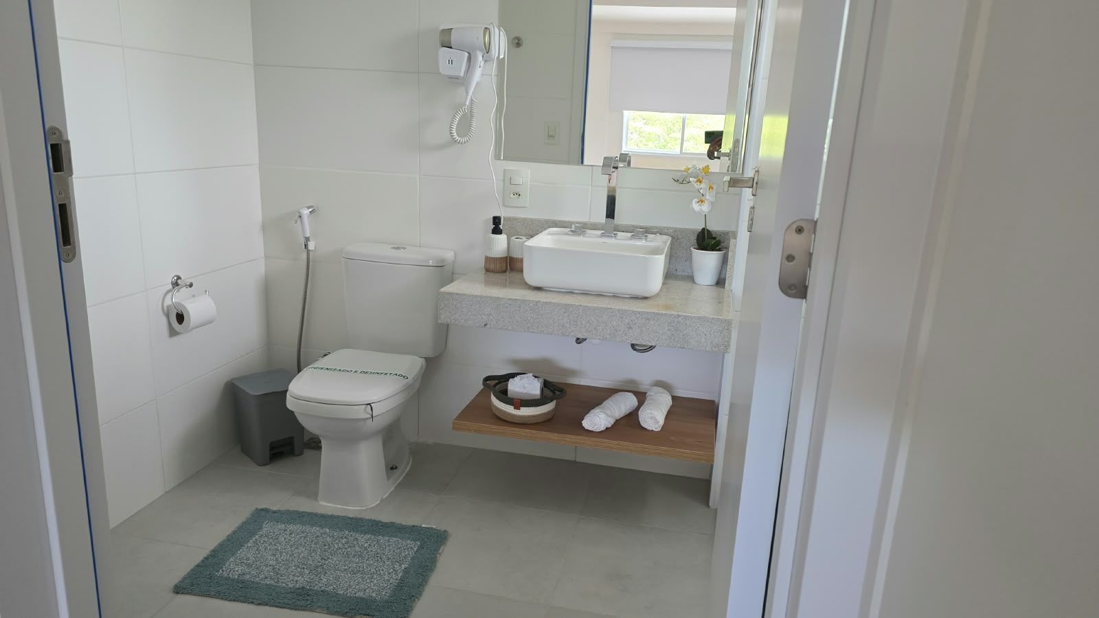 A bathroom with a toilet, sink, and a towel rack.