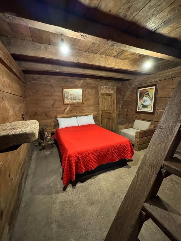 Une pièce en bois avec un lit, une chaise et une petite table.
