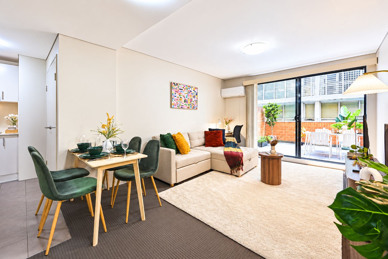 A modern living room with a dining area, a sofa, and a coffee table.
