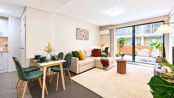 A modern living room with a dining area, a sofa, and a coffee table.