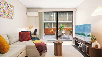 A modern living room with a sofa, a coffee table, and a flat-screen TV.