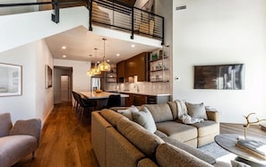 A modern interior with a dining area, kitchen, and seating space. - IL CERVO - The Stag (Park City)