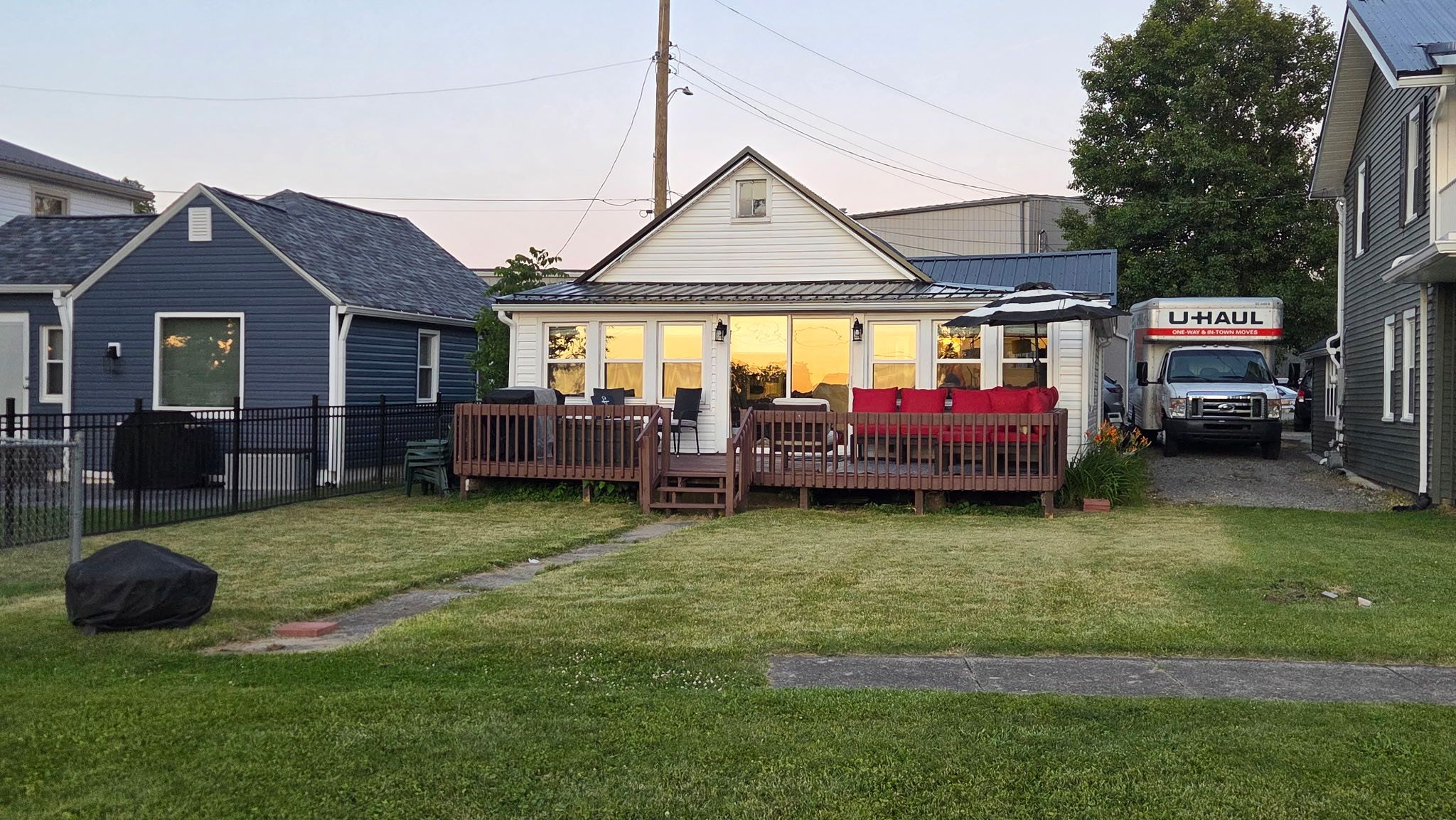 A residential property with a fenced yard, a deck, and a U-Haul truck parked outside.