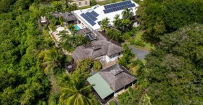 A residential area with multiple houses, some with solar panels, surrounded by dense greenery. - L'Horizon Luxury Sea View Villa (Bridgetown)