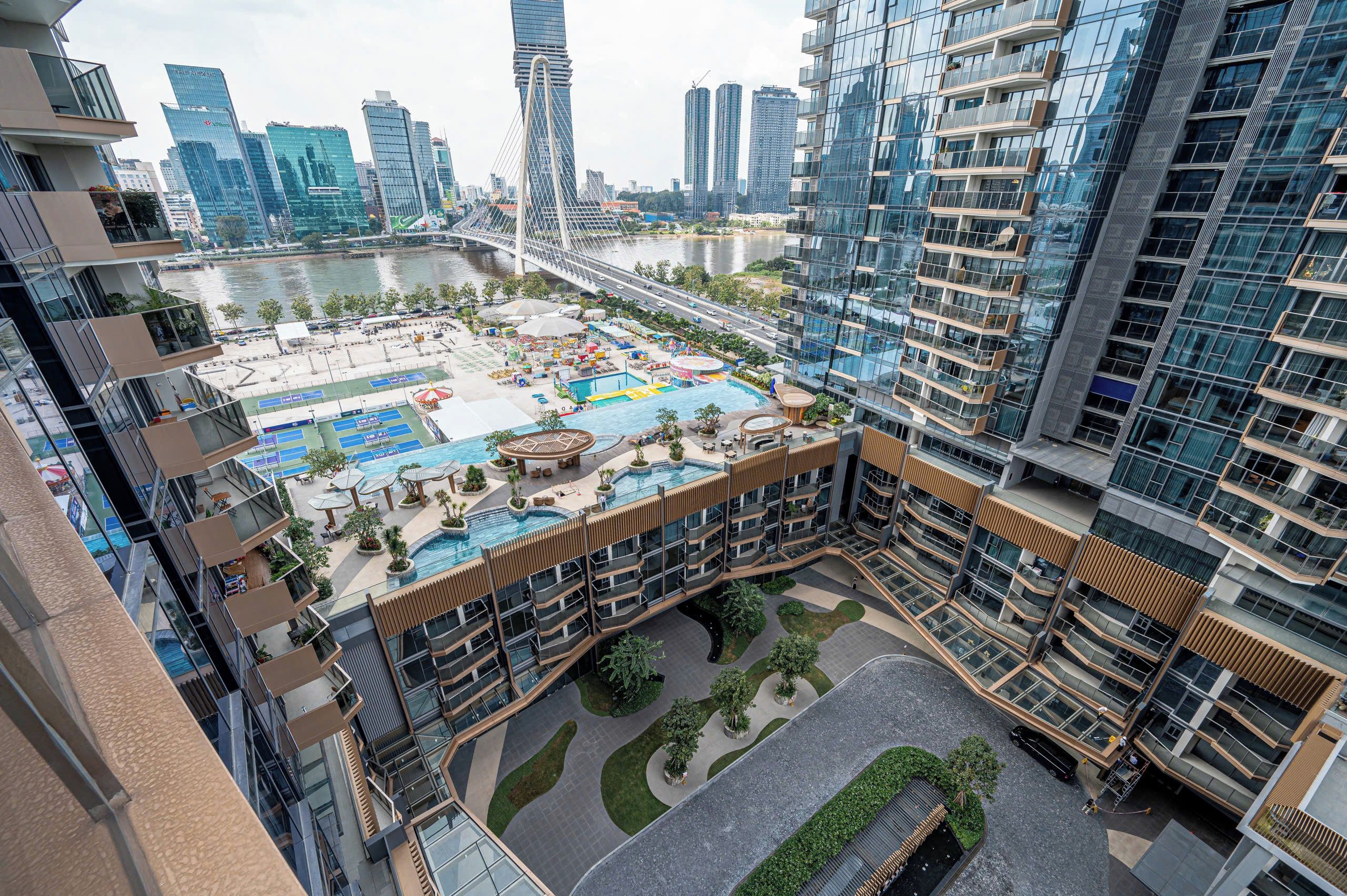 A high-rise building with a rooftop pool area, surrounded by other high-rise buildings.