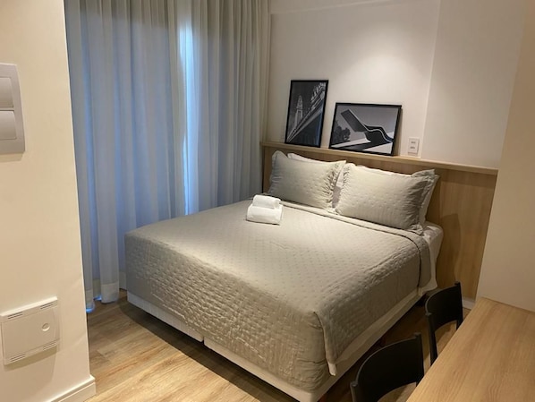 A neatly made bed with a headboard, a bedside table, and a chair. - Brand-New Studio 150m from Vila Madalena Metro WSS144 (São Paulo)