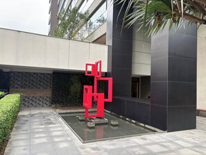 A modern building with a geometric red sculpture in the courtyard. - 1BR Apt w/ Pool, Parking & Metro – Campo Belo EGB124 (São Paulo)
