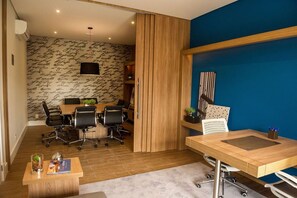 A modern office space with a conference table, chairs, and a wooden partition. - 1BR Apt w/ Pool, Parking & Metro – Campo Belo EGB124 (São Paulo)