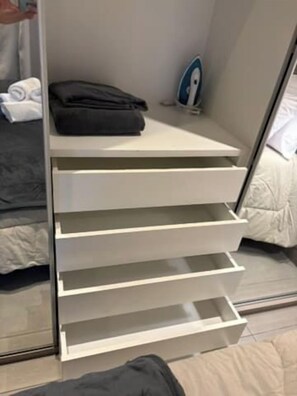 A bedroom with a bed, a white bedside table, and a white drawer unit with multiple compartments. - Studio w/ Pool & Parking – Near Oscar Freire Metro VNCV306 (São Paulo)