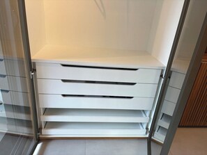 A room with a sliding door leading to a storage area with multiple drawers. - Brand-New Studio near Brooklin Metro HMB616 (São Paulo)