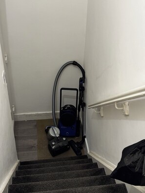 A stairwell with a vacuum cleaner and a bag on the stairs. - Lovely 3-bedroom apartment in South Shields near the coast (South Shields)