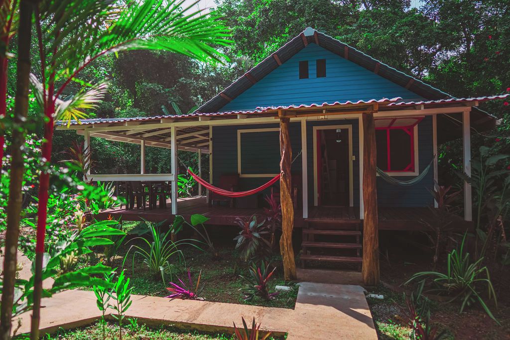 A blue house with a porch and a hammock.