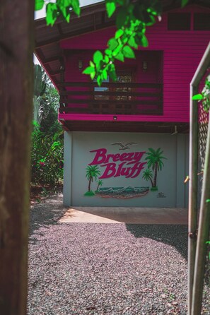 A building with a sign reading 'Breezy Bluff' and a mural of palm trees and waves.