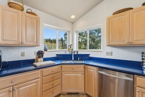 A kitchen with wooden cabinets, a stainless steel dishwasher, and a blue countertop. - Sweet Home Colorado!!!! Where the skies are Crystal Blue!!!! (Kremmling)