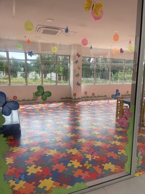 A room with large windows, a colorful puzzle-patterned floor, and butterfly decorations. - 🌴 Beachfront Paradise in Santa Marta | Pool, Spa & Caribbean Escape 🌊 (Magdalena)