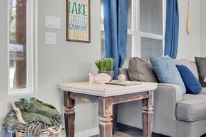 A cozy living room with a sofa, a small table, and a decorative sign on the wall. - Pet-Friendly 3-bedroom house walking distance to Canyon Lake and Comal Park (Canyon Lake)