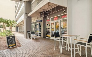 Un área con mesas y sillas para disfrutar al aire libre, un letrero que indica un restaurante y un edificio con el rótulo Southern Sandwich Co.