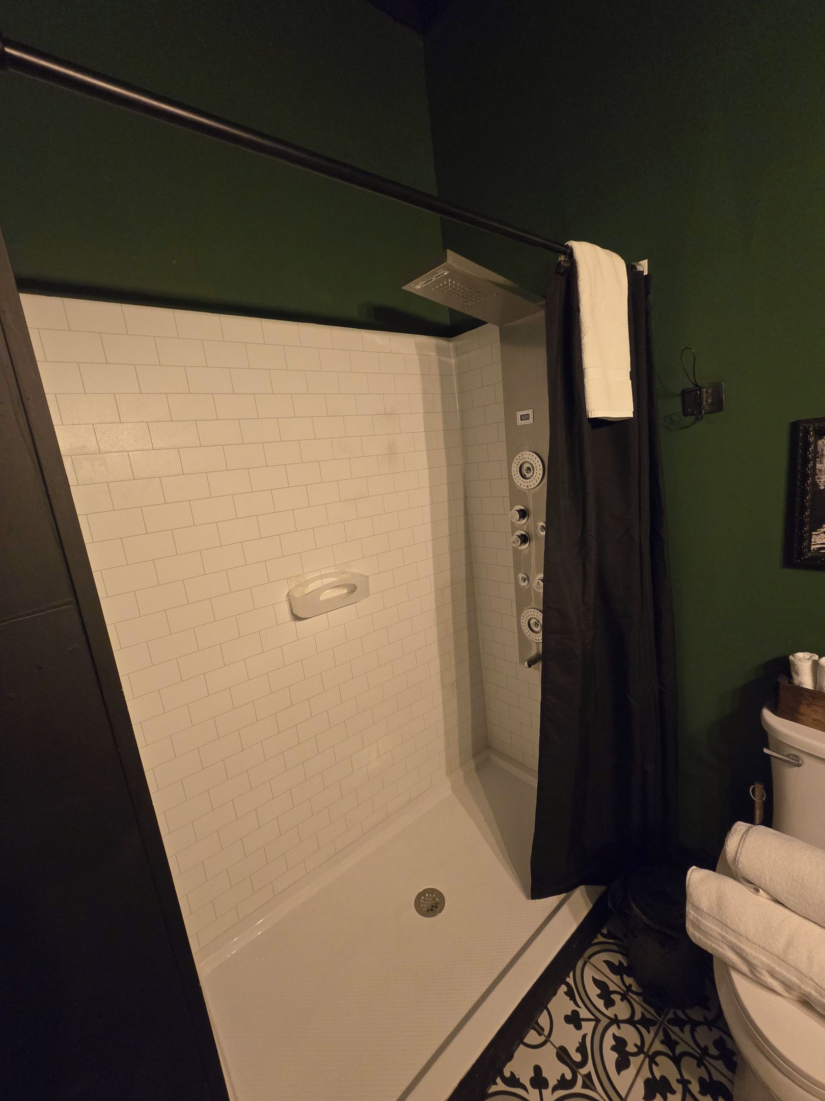 A bathroom with a shower, a toilet, and a wall-mounted sink.