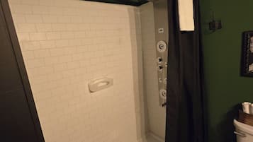 A bathroom with a shower, a toilet, and a wall-mounted sink.