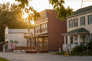 A building with a 'Pizza' sign, a porch, and a staircase leading to a second floor. - NEW! The Gatsby Speakeasy - Marthasville,MO (Marthasville)