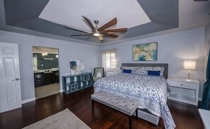 A bedroom with a large bed, a ceiling fan, a bench, and a nightstand. - Gated/ 2 Master Bed / 2.5 bath/ Private Screened in Pool-10min from Bonita Beach (Bonita Springs)