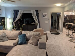 A living room with a sofa, a coffee table, and a dining area with chairs. - Gated/ 2 Master Bed / 2.5 bath/ Private Screened in Pool-10min from Bonita Beach (Bonita Springs)