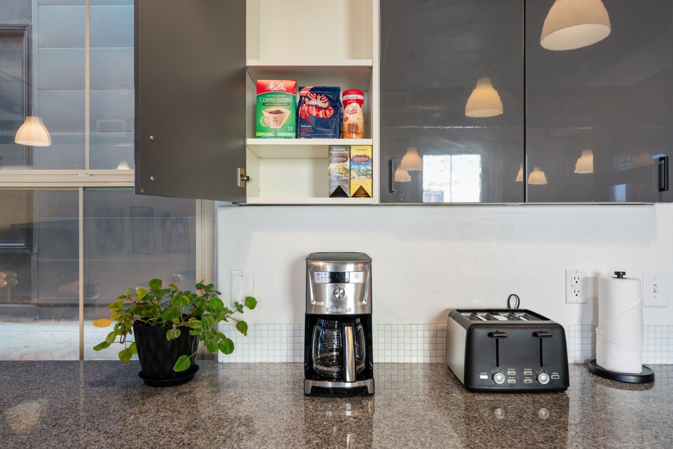 A kitchen with a coffee maker, toaster, and coffee filters on the counter.