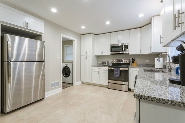 A modern kitchen with stainless steel appliances, a built-in oven, microwave, and a granite countertop.