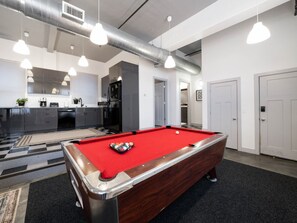 A pool table in a room with a kitchen in the background, a door, and a hallway. - Central Downtown Gem | Perfect for BYU Games! (Provo)