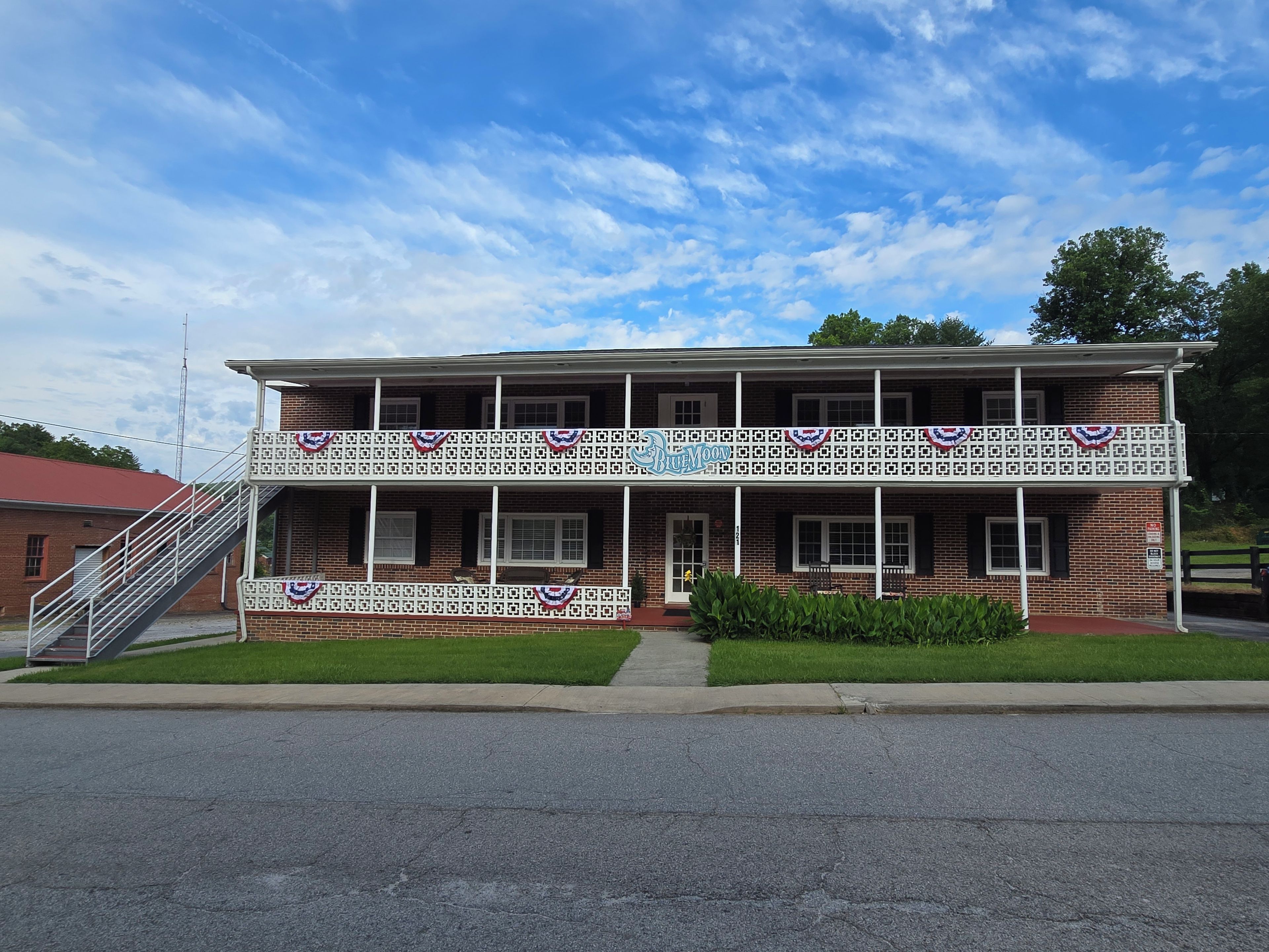 A two-story building with a balcony, a staircase, and a sign that reads 'Blue Moon'.
