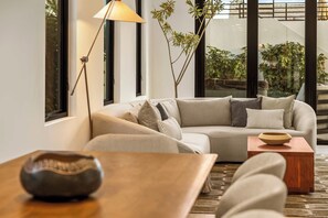 Ein stilvolles Wohnzimmer mit einer Couch, einem Couchtisch und einer Lampe.