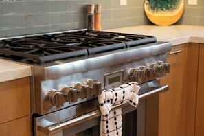 A stainless steel range with a digital clock, a gas stove, and a built-in oven. - 5BR | Hot Tub | Walk to Beach | Family House (San Diego)