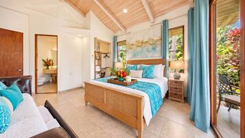 Un dormitorio con una cama grande, techo de madera, baño con inodoro y vistas a zonas verdes.