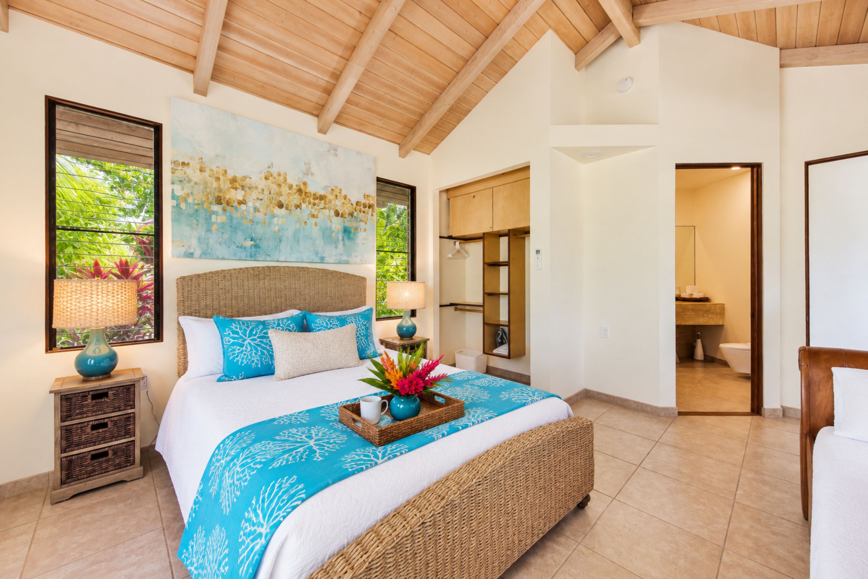 Een ruime slaapkamer met een groot bed, een houten plafond en uitzicht op de omgeving.