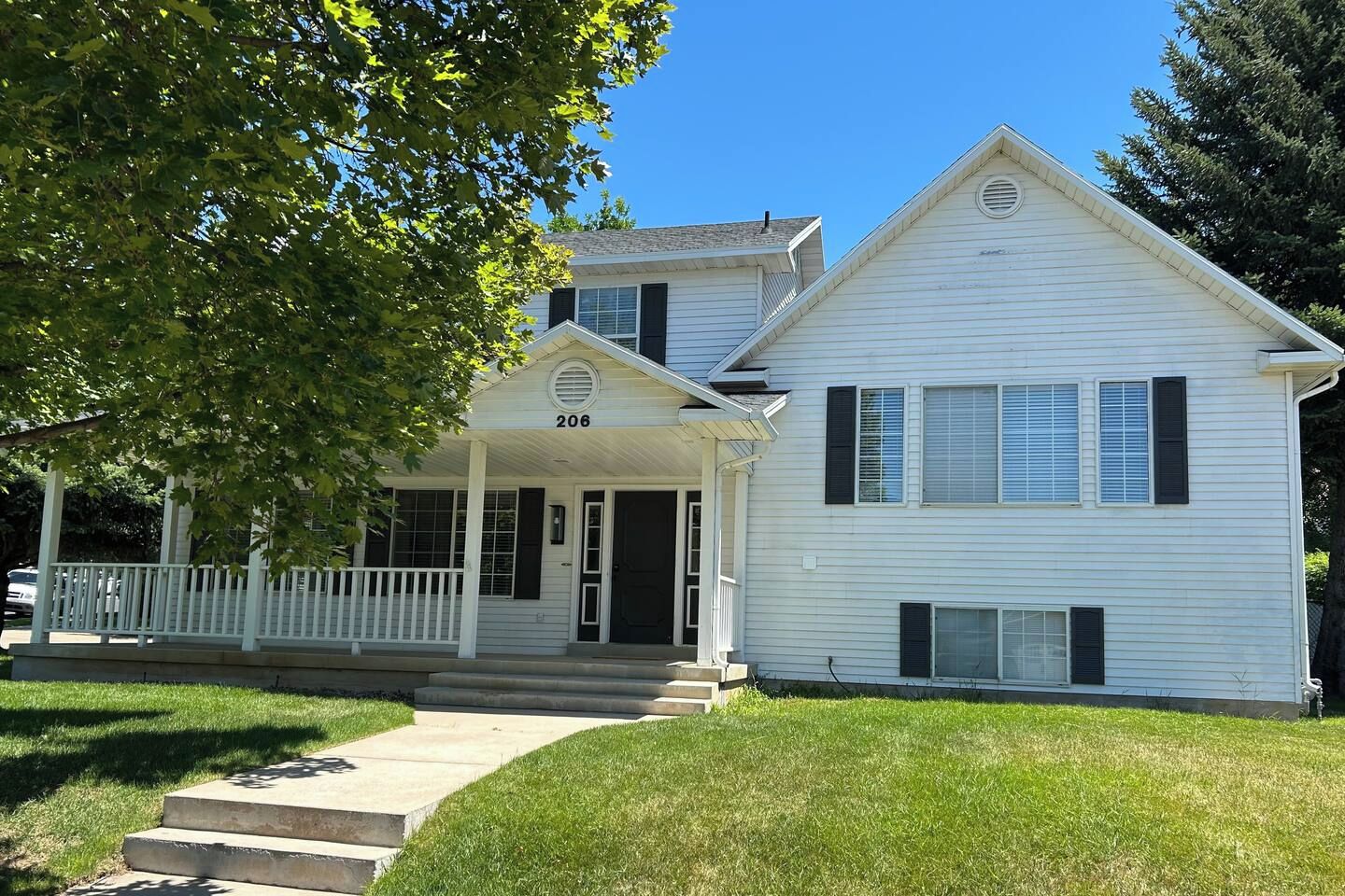 A two-story house with a porch and a number 206 on the front door.