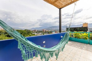 A hammock on a blue balcony with a cityscape view. - Utop a 3 East-charming Loft Wi-fi AC Selfcheck In (Medellín)