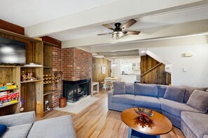 Ein modernes Wohnzimmer mit Kamin, Fernseher und einer Couch.