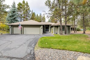 A two-story building with a garage, a driveway, and a well-maintained lawn. - 8 Quelah - Sunriver Escape w/ 10 SHARC Passes, Pool Table, Deck (Sunriver)