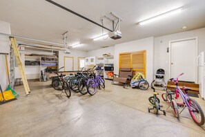 Un espacio interior amplio con bicicletas, un proyector y estanterías.