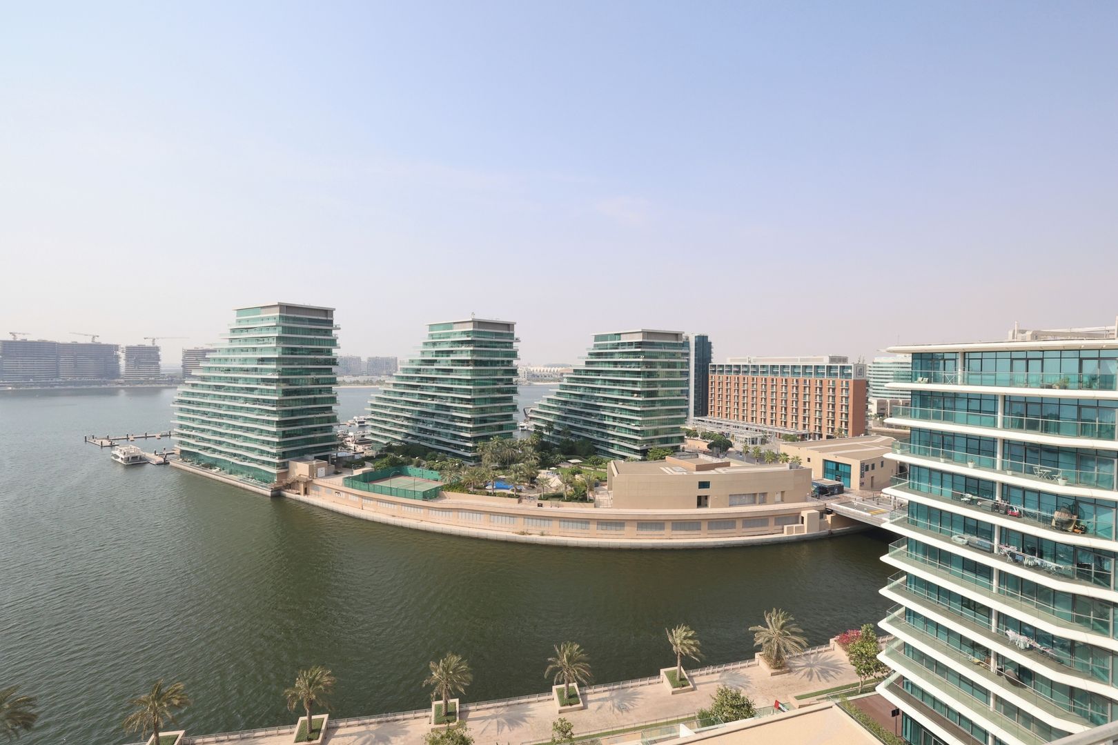 A waterfront hotel with multiple high-rise buildings, a marina, and a landscaped promenade.