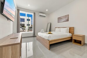 Restful bedroom featuring a comfortable bed, air conditioning, flat-screen TV, and a full-body mirror. - Brand New 3BR Villa | Pool, BBQ & Lighthouse View (Noord)