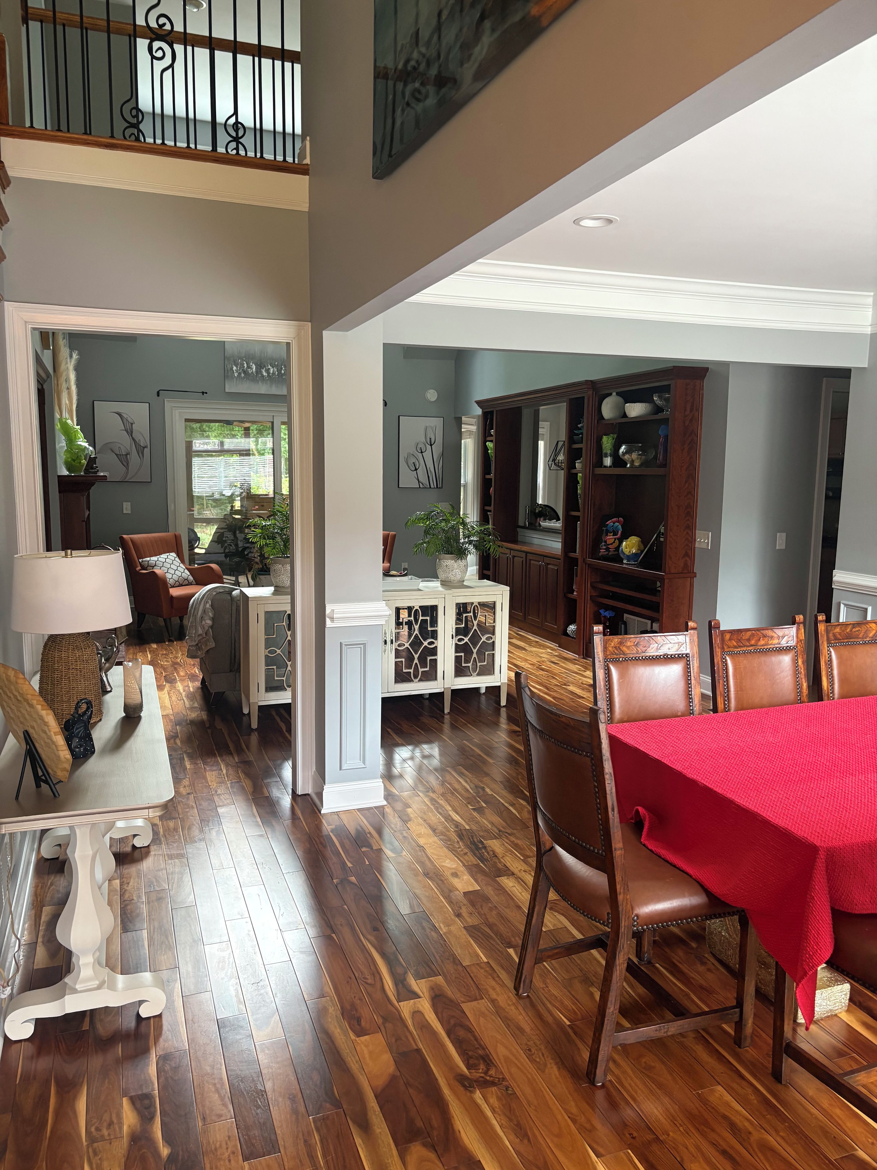 A spacious living area with a dining table, chairs, and a red tablecloth.